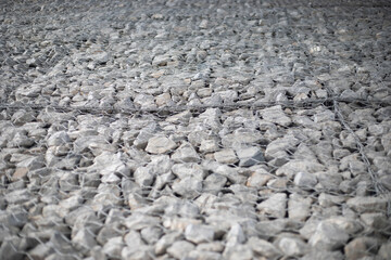 Texture of stones. Stones under the net. Drainage system.