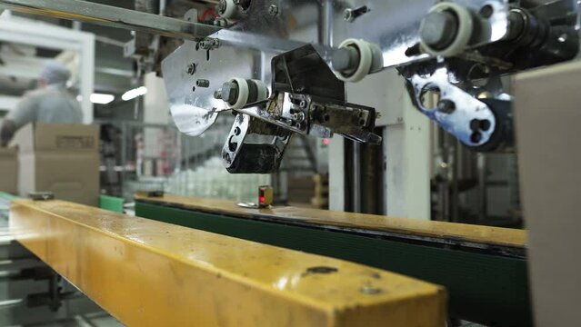 Medical Supply Production. A close-up of a Packaging machine that is Sealing Multiple Cardboard boxes with the Tape. Automatic Machine for Storing the Product. Manufacturing Process. Heavy Machine.