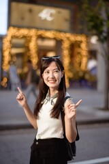 City life radiates joy with a young Asian woman, a symbol of confidence, style, and a carefree...