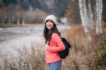 Journey to the peak, Asian woman in a pink fleece climbing alone. Elegant portrait by the lake, capturing the achievement, excitement, and scenic beauty of Japan.