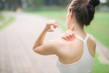 Shoulder pain problem. woman jogger. 30s asian female wearing white sportswear holding her shoulder...