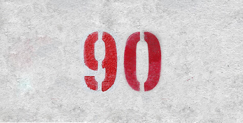 Red Number 90 on the white wall. Spray paint.