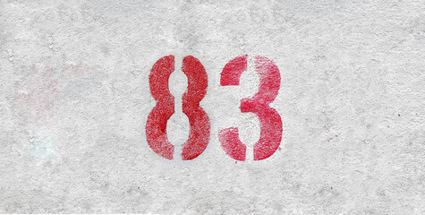 Red Number 83 on the white wall. Spray paint.