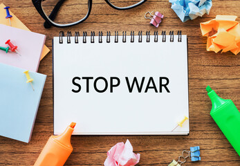 A notepad with STOP WAR written on it, surrounded by colorful office materials.