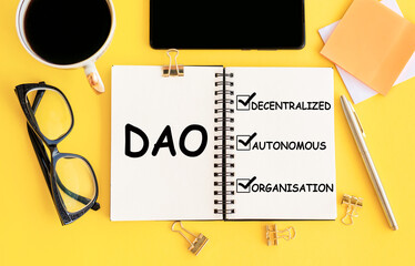 A notepad with the word DAO written on it placed next to a cup of coffee.