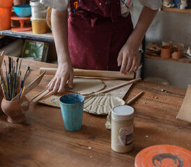 young girl working with clay on the table in a pottery workshop