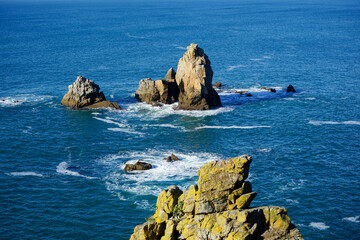 Îlots rocheux émergeant des eaux de la mer d'Iroise, une vision emblématique de la côte bretonne.