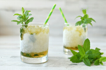 Classic Mint Julep cocktail in frosted glass, green straws mint garnish to celebrate Kentucky Derby.