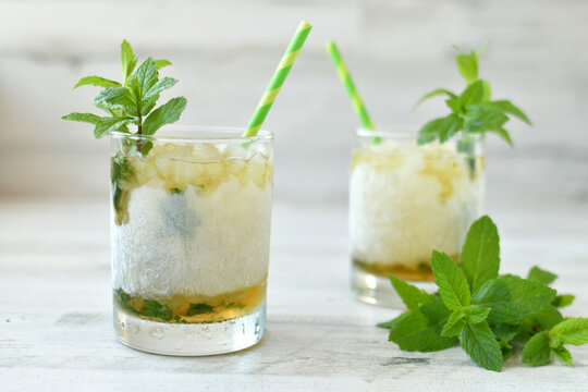 Classic Mint Julep cocktail in frosted glass, green straws mint garnish to celebrate Kentucky Derby.