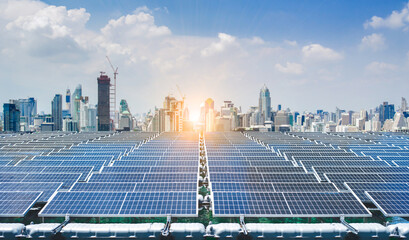 An expansive array of solar panels captures renewable energy against the backdrop of a modern city skyline bathed in the light of a setting sun.