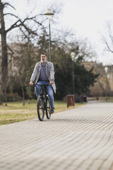 Man Riding a Bike Down a Sidewalk In the Park