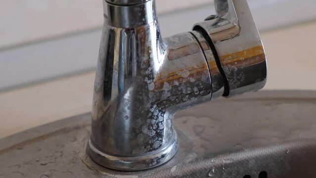 Scale or deposits on the faucet from hard water. Limescale deposits on the water tap