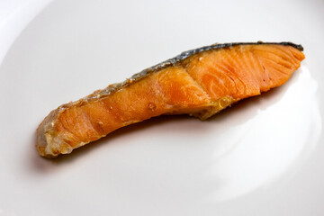 お皿に乗せた切り身の焼いた鮭