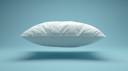   A white pillow atop another, against a light blue backdrop Shadow cast below lower pillow