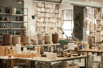 Clay pots sitting on shelves and tables in a ceramics workshop