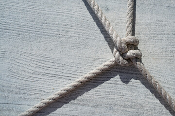 Rope knot on gray wooden background