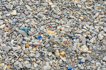 After a storm, plastic garbage washes up on the seashore. Consequences of thoughtless human activity and negative impact on the environment