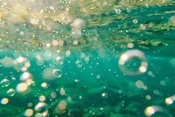 Bubbles and bokeh underwater in clear green ocean