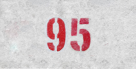 Red Number 95 on the white wall. Spray paint.