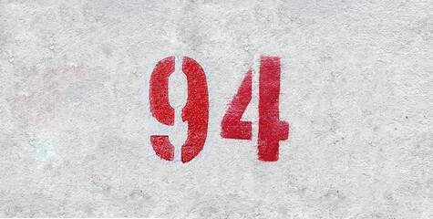 Red Number 94 on the white wall. Spray paint.