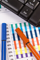 Ballpen, computer keyboard and financial chart showing production or sales statistics. Business