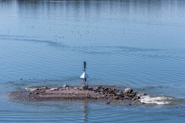 A small rock with and light house in the outer archipelago a sunny spring day in Stockholm