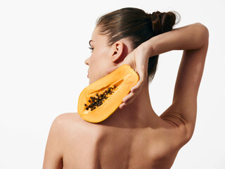Woman holding ripe papaya fruit, isolated on white background with back facing camera, healthy...
