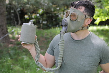 Man wearing vintage gas mask in natural setting 