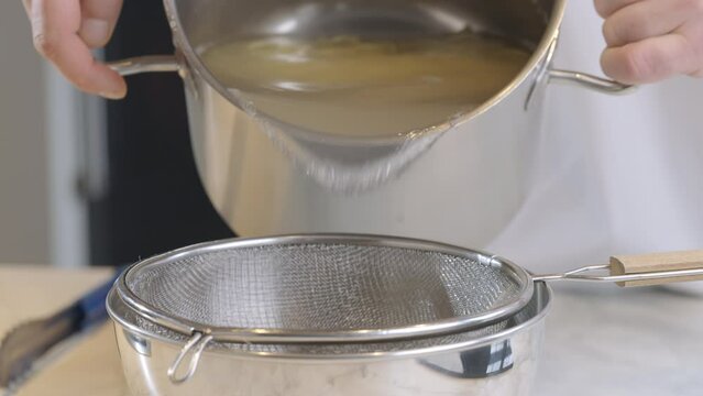 Cook draining spaghetti in colander slow motion video.