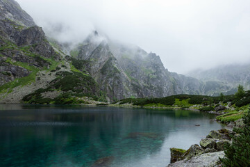 Morskie Oko (Eye of the Sea) in Tatra National Park in Poland on rainy cloudy day. - obrazy, fototapety, plakaty