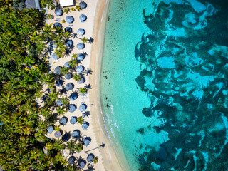 Aerial top down view of the beautiful Morris Bay Beach with palm trees and emerald see, Antigua and...