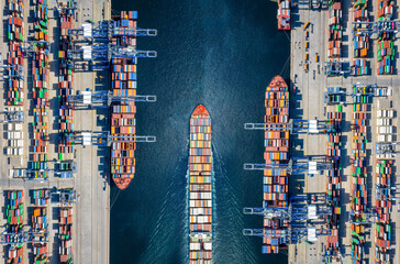 Aerial top down view of a large container cargo ship terminal with loading activity and vessel...