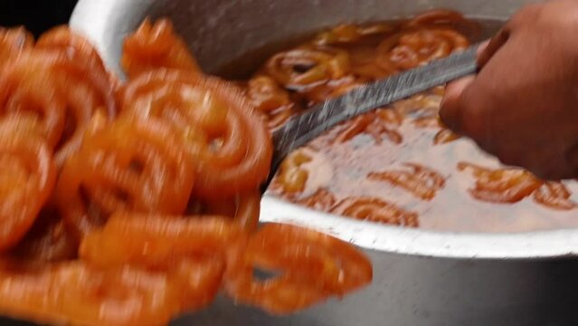 Fried Jalebi dipped in sweet syrup. Jalebi dipped in sweet syrup is ready to serve. Jalebi making the recipe.