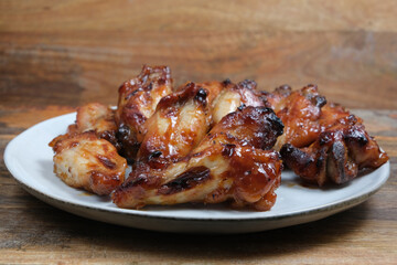 Teriyaki chicken wings on ceramic plate..