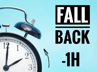  Fall back or time change concept. Alarm clock at 3 o'clock changing to Winter Time