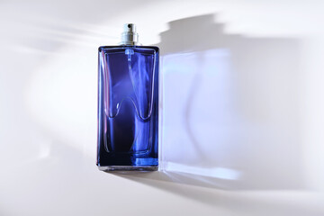 Perfume spray in a blue bottle on a white background.