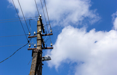 Old power line pole against blue sky in a nice sunny day
