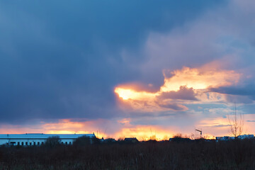 Fototapeta premium Colorful sunset sky with clouds against the background of the city.