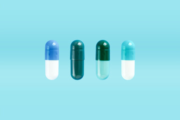 Various two-piece hard starch capsule on blue background with copy space. Biologically active additives. Health concept.