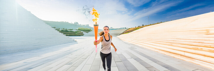 runner holding a torch in a stadium