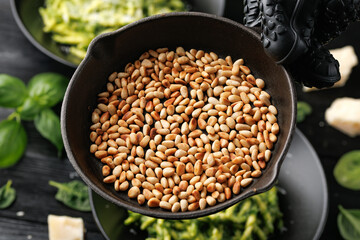Roasted pine nuts on a cast iron pan ready to be sprinkled over pasta