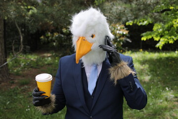 Businessman with an eagle face making a phone call