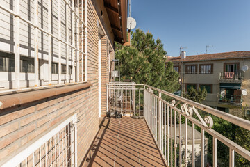 Narrow terraces of apartment building with terracotta stairs with white metal railings and large...