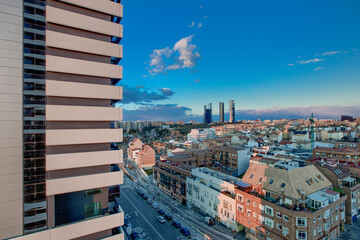 Facades of residential buildings and views of the skyline of northern Madrid