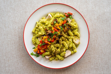 Plate of Avocado Chicken Pasta served with baked pepper, tomatoes and herbs..