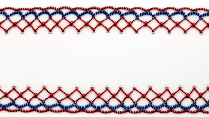 A close-up of a geometric embroidery design with bold red, blue, and white threading on a textile surface