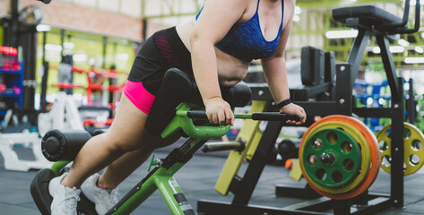 fat motivated woman exercise workout machine. fitness gym member trying to balance body exercise to...