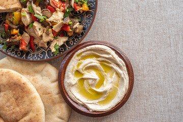 Chicken meat with grilled vegetables, hummus plate, pita bread for Israeli lunch.