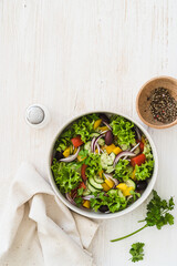 Bowl of fresh salad with vegetables on white wood rustic background