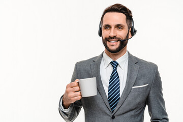 Happy IT support manager chat manager in headset drinking coffee isolated over white background....